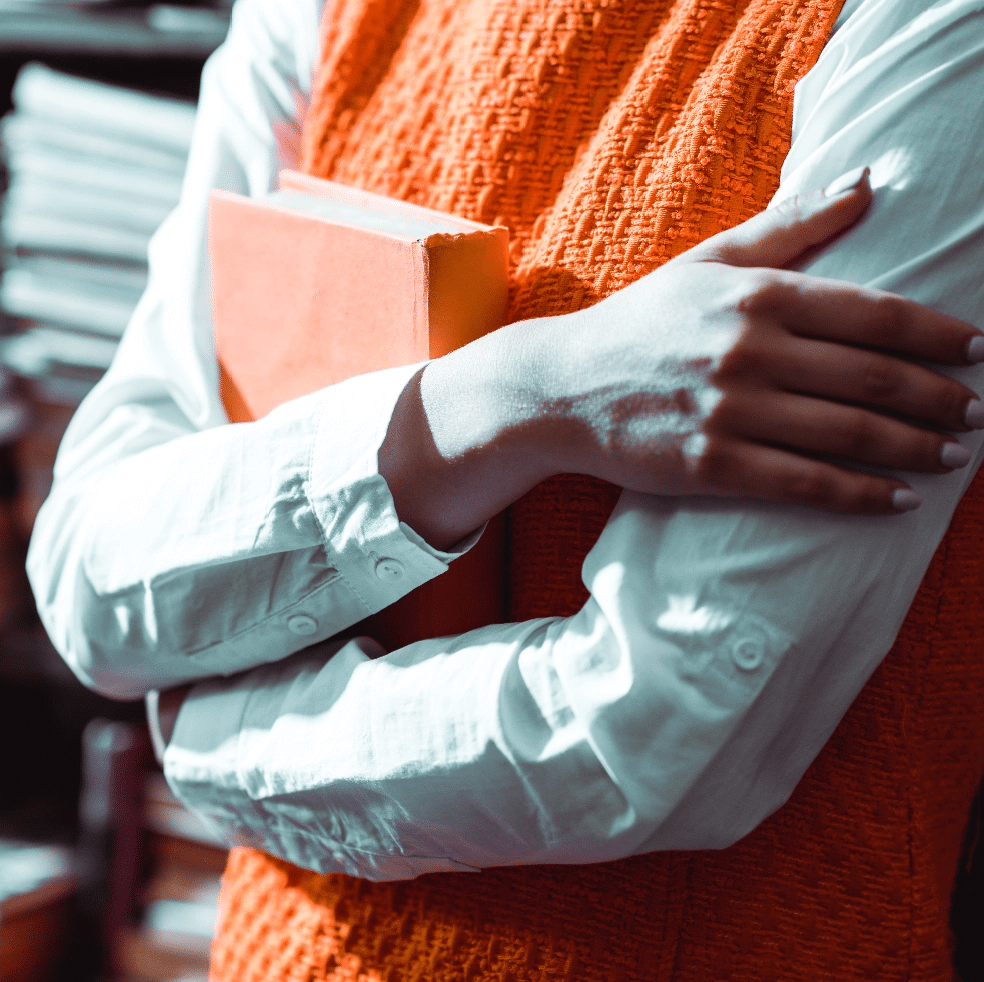 cropped-view-of-woman-with-crossed-arms-holding-books